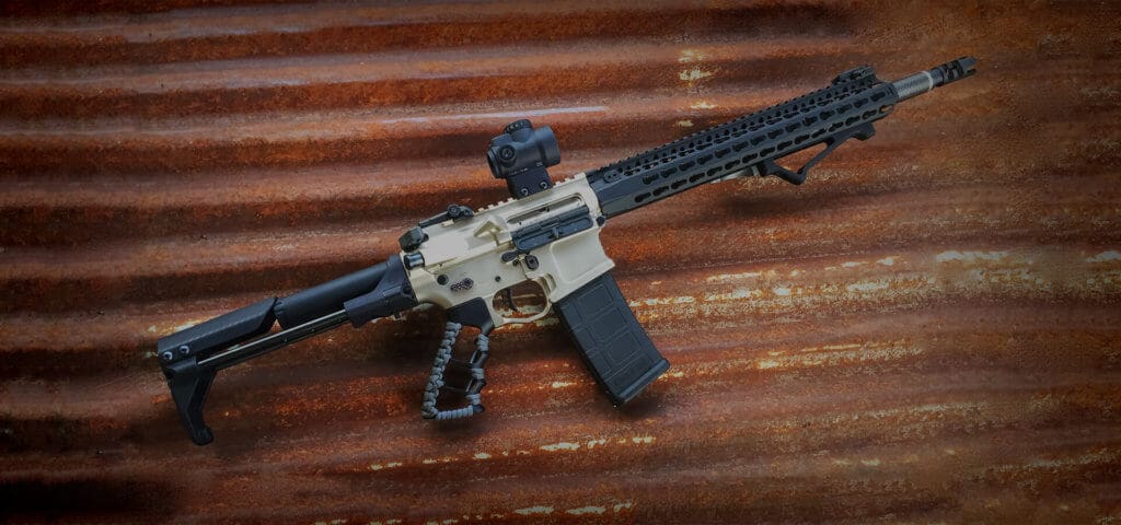 An AR-15 featuring a silver stock and black barrel and accessories