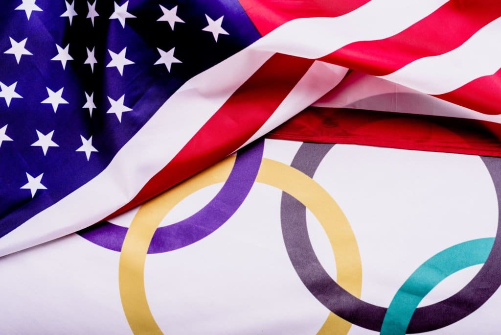 Flag of the United States folded over the Olympic rings to illustrate USA Olympic Shooting Team Earns Six Medals